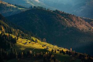 Colorful autumn landscape in the mountain village. Foggy morning in the Carpathian Mountains in Romania. Amazing nature. photo