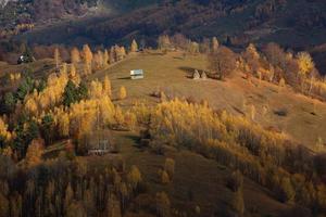 Colorful autumn landscape in the mountain village. Foggy morning in the Carpathian Mountains in Romania. Amazing nature. photo