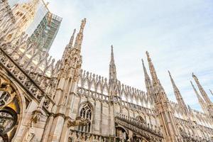 Roof of Milan Cathedral Duomo di Milano with Gothic spires and white marble statues. Top tourist attraction on piazza in Milan, Lombardia, Italy. Wide angle view of old Gothic architecture and art. photo