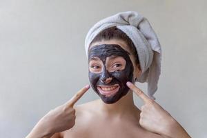 mujer aplicando mascarilla nutritiva negra en la cara foto