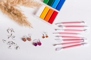 Ready-made polymer clay earrings and tools for work. Handmade and leisure. Top view. photo