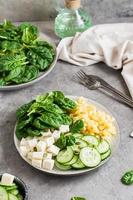 Bowl with pasta, cucumber, cheese and spinach on the table. Vertical view. Close-up photo