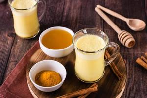 Turmeric honey golden milk in glasses on the table. Home treatment, improve immunity. photo