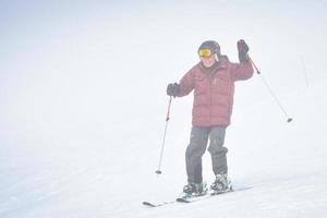 Gudauri, Georgia,2022 - Elderly adventurous caucasian man ski downhill excited on snowy conditions in winter ski resort on vacation photo