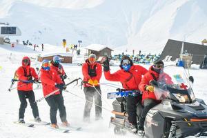 Gudauri, Georgia, 2022 - ski rescue team on practice in winter ski resort enjoy work have fun. Snowmobile drag rescue team outdoors photo