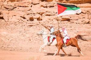 wadi rum, jordania, 2022: gran ataque de combatientes de la revuelta árabe en wadi rum en la nueva experiencia de viaje de aventura en tren ferroviario hijaz. populares nuevas actividades jordan foto