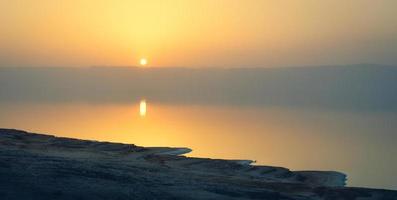 Scenic panoramic view of dead sea shoreline in misty evening on sunset from viewpoint in Jordan photo