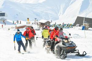 Gudauri, Georgia, 2022 - ski rescue team on practice in winter ski resort enjoy work have fun. Snowmobile drag rescue team outdoors photo