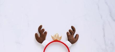 diadema elegante con forma decorativa de asta de reno para la fiesta de navidad y celebración sobre fondo de mármol blanco, estilo de pancarta para texto foto