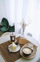 mesa de café, café helado y caliente con un delicioso pastel en la mesa en un acogedor estilo de café, estilo minimalista e hipster foto