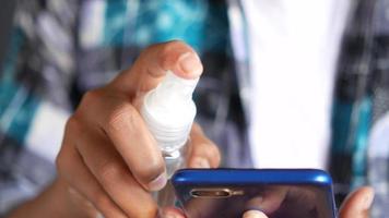 Spraying alcohol on smartphone, sanitizing video