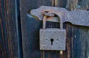 Lock on an old wooden door with rusty inserts photo