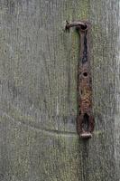 Old wooden gate closed on rusty padlock, texture photo