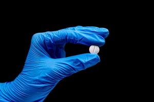 Medical pills  on isolated black background with reflection in hand photo