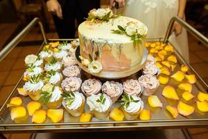 White wedding cake decorated by flowers fruits photo