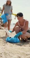 mãe e filha coletando lixo na praia vídeo vertical video