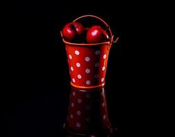 aluminum ice bucket laid in wait for use. stainless multi-colored bucket with red apples photo