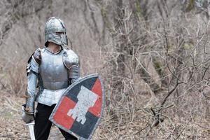 Noble warrior. Portrait of one medeival warrior or knight in armor and helmet with shield and sword posing photo