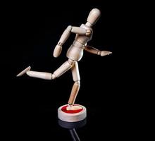 Image of wooden manikin on black background poses different posing photo