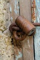 Lock on an old wooden door with rusty inserts photo