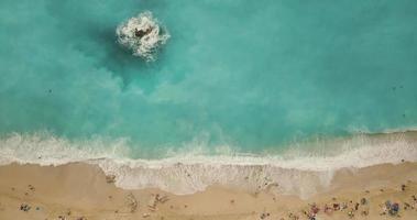 vista aérea da praia selvagem com pedras no mar em um dia ensolarado. video