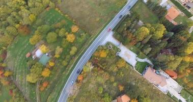 antenne vlucht over- weg Bij berg dorp in herfst 4k beeldmateriaal video