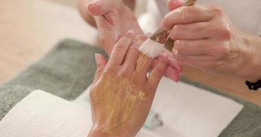 primer plano de la mano de una mujer irreconocible que recibe un tratamiento de spa de manicura de lujo en un salón de belleza. video