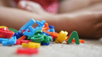 colorato lettera giocattolo magneti su il pavimento dove un' bambino giochi video
