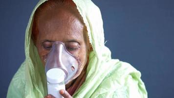 Older woman breathes with nebulizer, respiratory video