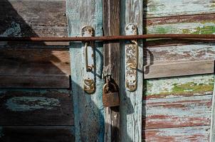 Lock on an old wooden door with rusty inserts photo