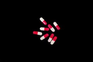 Medical pills on isolated on black background photo
