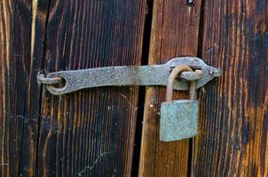 Lock on an old wooden door with rusty inserts photo