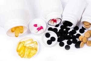 Medical pills spill out of a white jar on an isolated on white background photo