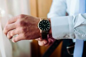 hombre poniendo reloj a mano, novio preparándose por la mañana foto