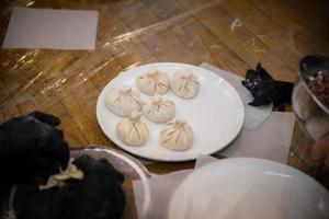 The hands of an old grandmother mold vareniks khinkali dumplings molding photo