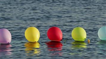 lustige bunte luftballons, die auf dem meerwasser schwimmen video