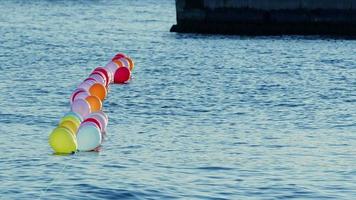 drôles de ballons colorés nageant sur l'eau de mer video