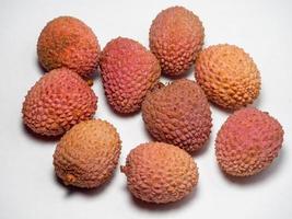 Lychee on the table. Chinese plum on a white background. Ripe fruit from Asia. Delicious, juicy product. photo