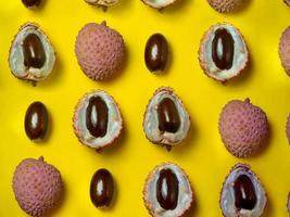 Pattern of cut lychees. Round pimply fruits. Chinese plum. Fruit peel. Peeling the lychee. Pieces of juicy fruit on a bright background. photo