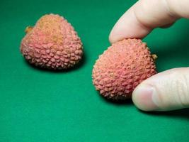 Lychee on the table. Chinese plum on a green background. Ripe fruit from Asia. Delicious, juicy product. photo