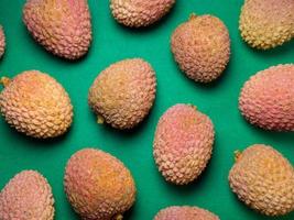 Lychee on the table. Chinese plum on a green background. Ripe fruit from Asia. photo