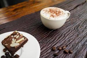 Hot cappuccino in white cup with wooden background,coffee is a popular drink all over the world. photo