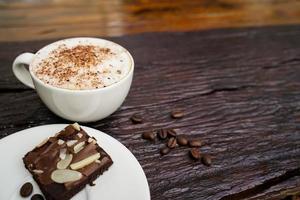 Hot cappuccino in white cup with wooden background,coffee is a popular drink all over the world. photo