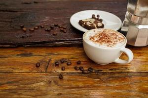 Hot cappuccino in white cup with wooden background,coffee is a popular drink all over the world. photo
