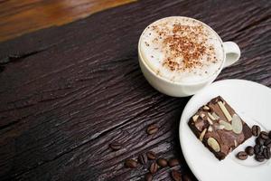 Hot cappuccino in white cup with wooden background,coffee is a popular drink all over the world. photo