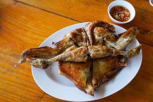 Grilled chicken in white plate on wooden floor - traditional Thai menu  It's a simple and popular dish. photo