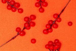 Decoration christmas concept, Bunch of red berries twig holly on orange background photo