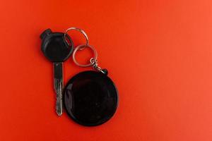 Black motorcycle key with black round keychain on red background. keychain mockup for design photo