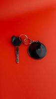 Black motorcycle key with black round keychain on red background. keychain mockup for design photo