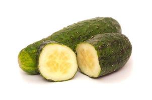 one , half and a slice of cucumber isolated on white background photo